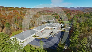 Aerial view of solar power plant with photovoltaic panels mounted on industrial building grounds for producing green