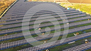 Aerial view of solar power plant under construction on green field. Assembling of electric panels for clean ecologic