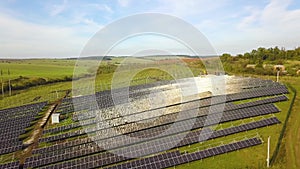 Aerial view of solar power plant under construction on green field. Assembling of electric panels for producing clean