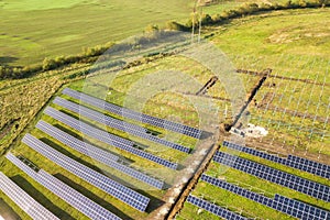 Aerial view of solar power plant under construction on green field. Assembling of electric panels for producing clean