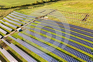 Aerial view of solar power plant under construction on green field. Assembling of electric panels for producing clean