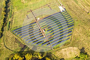 Aerial view of solar power plant under construction on green field. Assembling of electric panels for producing clean ecologic