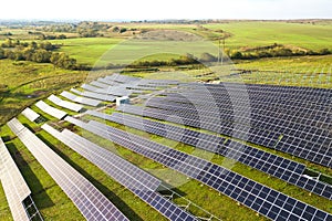 Aerial view of solar power plant under construction on green field. Assembling of electric panels for producing clean ecologic