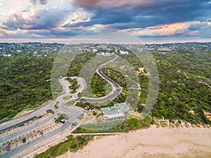 Aerial view of Sorrento Back Beach with winding road and All Smiles Sorrento Ocean Beach wedding venue at sunrise. Mornington Pen