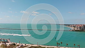 Aerial view of South Pointe Park and buildings in Miami Beach with boat speeding up in canal