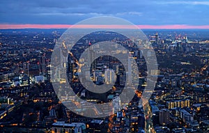 Aerial view of south west London, blue hour just after sunset, orange yellow street lights starting to glow