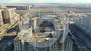 Aerial view and span over a construction site with cranes of a multi-storey residential complex