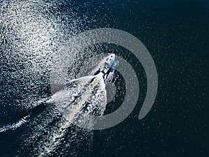 Aerial view of speed Boat or yacht at blue sea or lake leaving a wake