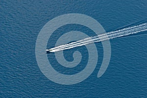 Aerial view of speeding motor boat on a deep blue colored sea