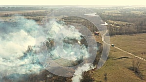 Aerial View. Spring Dry Grass Burns During Drought Hot Weather. Bush Fire And Smoke. Fire Engine, Fire Truck On