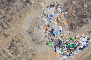 Aerial view of stack of different types of garbage pile, plastic bags, and trash withempty site in industrial factory in