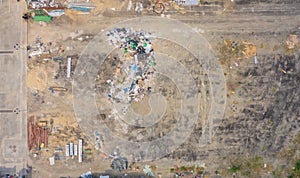 Aerial view of stack of different types of garbage pile, plastic bags, and trash withempty site in industrial factory in