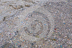 Aerial view of stack of different types of large mountain garbage pile, plastic bags, and trash with a tractor car in industrial