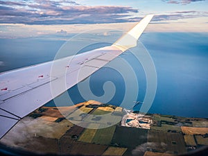 Aerial view of Store Heddinge, Denmark, with airplane wing above patchwork fields and Stevns Klint