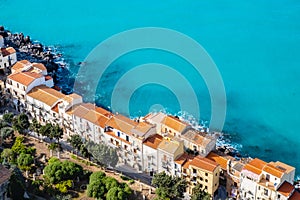 Aerial view of street in Cefalu old town and turquoise sea water on Sicily island, Italy. Medieval seashore village with