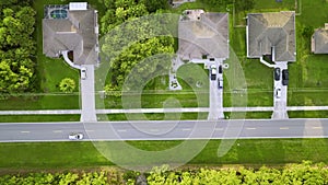 Aerial view of street traffic with driving cars in small town America suburban landscape with private homes between