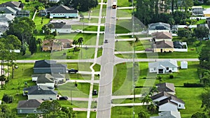 Aerial view of street traffic with driving cars in small town America suburban landscape with private homes between