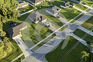 Aerial view of street traffic with driving cars in small town. American suburban landscape with private homes between