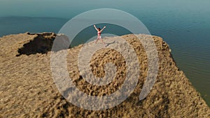 aerial view of stretching exercises outdoors. drone flight around fitness woman jogger doing exercises and stretches at