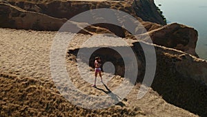 aerial view of stretching exercises outdoors. drone flight around fitness woman jogger doing exercises and stretches at