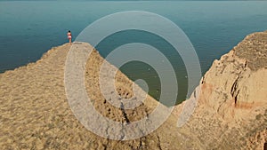 aerial view of stretching exercises outdoors. drone flight around fitness woman jogger doing exercises and stretches at