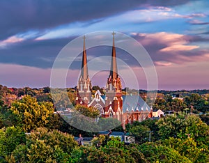 Aerial view of a stunning sunset over a picturesque church surrounded by lush greenery