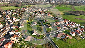 Aerial view of suburban landscape with private homes between green fields in quiet french residential area