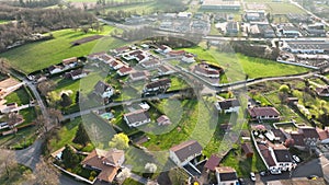 Aerial view of suburban landscape with private homes between green fields in quiet french residential area