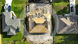 Aerial view of suburban private house wit wooden roof frame under construction in Florida quiet rural area