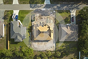 Aerial view of suburban private house wit wooden roof frame under construction in Florida quiet rural area