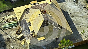 Aerial view of suburban private house wit wooden roof frame under construction in Florida quiet rural area