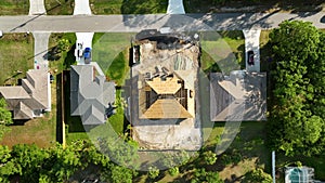 Aerial view of suburban private house wit wooden roof frame under construction in Florida quiet rural area