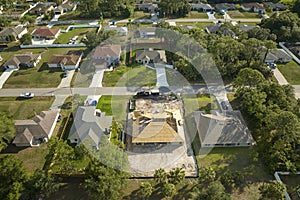 Aerial view of suburban private house wit wooden roof frame under construction in Florida quiet rural area