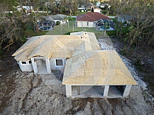 Aerial view of suburban private house with wooden roof frame under construction in Florida quiet rural area