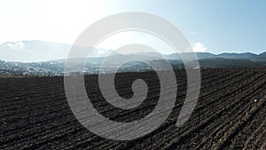 Aerial view of summer farm fields with dried soil. Shot. Agriculture industry concept, endless rows of plants growing on