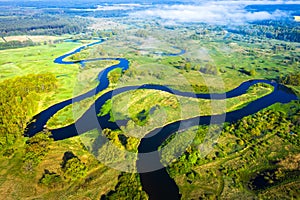 Aerial view on summer river. River stream on green meadow. Summer nature landscape. Drone view on riverside