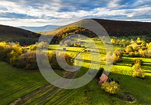 Aerial view in summer in Slovakia. Ggreen meadows and fields, grass and trees, rural road at dawn in spring. Top drone view of