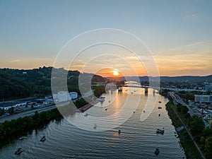 Aerial view of the sun setting behind boaters on the river