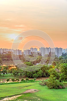 Aerial view sun setting behind park lakeside apartments in Singapore