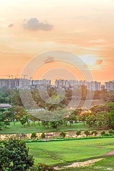 Aerial view sun setting behind park lakeside apartments in Singapore