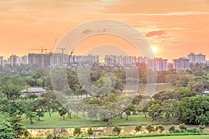 Aerial view sun setting behind park lakeside apartments in Singapore