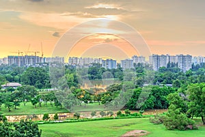 Aerial view sun setting behind park lakeside apartments in Singapore