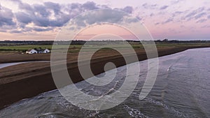 An aerial view of the sun setting over the coast at Shingle Street in Suffolk