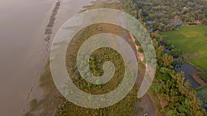 Aerial view of the Sundarbans shore at sunset in the India, the biggest mangrove forest in the world. The embankments built to