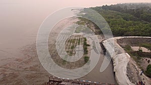 Aerial view of the Sundarbans shore at sunset in the India, the biggest mangrove forest in the world. The embankments built to