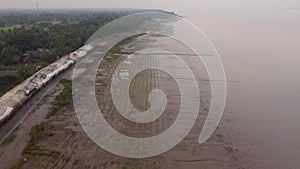 Aerial view of the Sundarbans shore at sunset in the India, the biggest mangrove forest in the world. The embankments built to