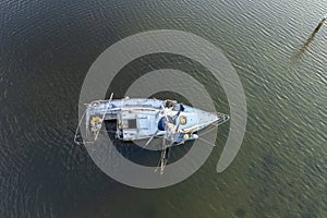 Aerial view of sunken sailboat on shallow bay waters after hurricane in Manasota, Florida