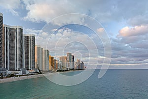 Aerial view of Sunny Isles Beach city with luxurious highrise hotels and condos on Atlantic ocean shore at sunset