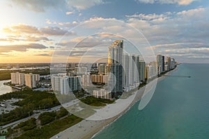 Aerial view of Sunny Isles Beach city with luxurious highrise hotels and condos on Atlantic ocean shore at sunset