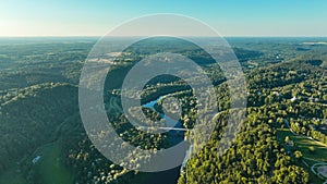 An aerial view A sunny summer evening The Gauja river flows between green forests and a bridge crosses.